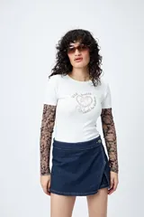 Remera blanca de corte ajustado con cuello redondo y mangas cortas. Presenta una estampa frontal en color marrón con el texto 'Wild hearts can't be broken' y un diseño de caballo dentro de un corazón.