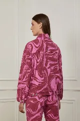 Campera de jean con estampado abstracto en tonos rosa y marrón.