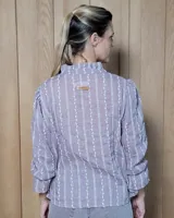 Blusa de algodón con cuello mao y volados, mangas largas con puños elásticos y corte holgado.