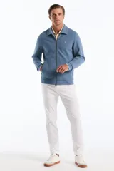 Campera de punto azul con cierre frontal completo, cuello tipo camisa y bolsillos ribeteados, decorada con el logo del pingüino bordado en el pecho.