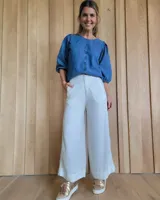 Pantalón palazzo color arena, de tiro alto y corte amplio.