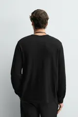 Camiseta de manga larga con cuello redondo, confeccionada en tejido de algodón con textura tipo waffle y acabados en rib.