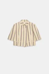 Blazer cropped ZW Collection confeccionada en mezcla de algodón, con diseño a rayas verticales en tonos azul y rojo sobre base beige. Presenta cuello redondo, manga corta, forro interior a tono y cierre frontal con un botón.