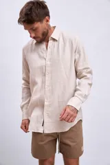 Camisa de lino color crudo, de corte recto, con cuello clásico y mangas largas.