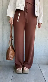 Pantalón marrón de tejido waffle con corte palazzo, cintura alta y lazo ajustable.