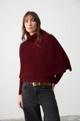 Capita de tejido de punto acanalado en color bordó, con cuello alto y diseño sin mangas con aberturas laterales.