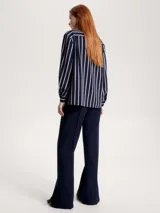 Camisa azul marino con rayas verticales blancas con rombos argyle, de corte amplio, cuello inglés y mangas largas con puños.