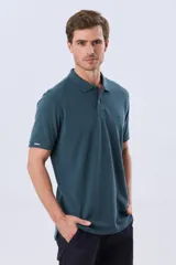 Remera polo de piqué de algodón color azul, de manga corta, con cuello camisero, cierre frontal de dos botones y pequeño logo bordado en el pecho.