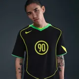 Camiseta Nike Total 90 Energy de color negro, con detalles en amarillo flúor y verde, de manga corta y cuello en V. Presenta un diseño inspirado en los años 2000 con el número 90 impreso en el centro del pecho y ribetes curvados en contraste.