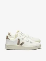 Championes urbanos Veja modelo V-10, color blanco con detalles en dorado metalizado en el logo lateral y el talón. Presentan perforaciones en la puntera, cierre con cordones y suela de goma en tono crema.