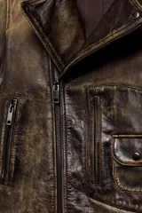 Chaqueta tipo biker de cuero con efecto desgastado, cuello de solapa, cierre frontal con cremallera metálica, bolsillos delanteros con cremallera y bolsillo pequeño con solapa, mangas largas con cremalleras en los puños y bajo con trabillas.