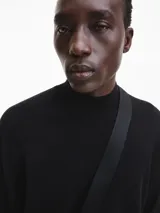 Sweater negro de cuello perkins confeccionado en lana merino extrafina. Tiene cuello, puños y bajo de canalé.