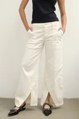 Pantalón de jean color crudo, de corte palazzo con aberturas en el ruedo y bolsillos laterales.
