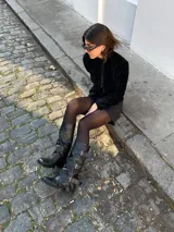 Botas de caña alta confeccionadas en cuero con efecto gastado. Presentan un diseño con tres correas horizontales ajustables mediante hebillas metálicas plateadas. Cuentan con un taco cuadrado bajo y suela de goma.