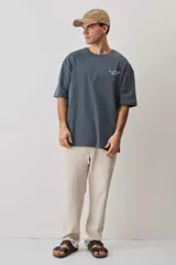 Remera oversize azul con mangas anchas, cuello redondo con textura tejida y estampa frontal pequeña a la altura del pecho.
