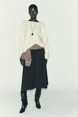 Jersey oversize de punto color crema, con cuello redondo y manga larga. Presenta costuras marcadas en los hombros y los laterales.