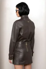 Campera de cuero color marrón con cuello clásico, cierre frontal con botones metálicos y detalles de volados en gamuza a lo largo de la botonadura y en los puños.