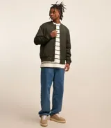 Campera bomber color beige, con cuello alto, cierre frontal con cremallera, bolsillos laterales y puños y cintura elastizados.