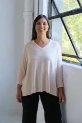 Sweater de punto en color crudo, con escote en V, mangas tres cuartos con puños acanalados y diseño holgado.