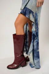 Vestido corto con estampado abstracto en tonos azules y beige. Presenta escote halter con pañuelo al cuello, corte irregular y ruedo con volados.