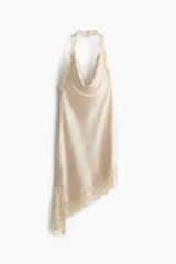 Vestido corto de satén color beige, con escote drapeado, diseño halter y bajo asimétrico con detalles de encaje.