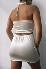 Minivestido marrón de satén con escote halter, abertura en el pecho y recortes laterales.