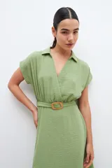Vestido midi color verde pistacho, de corte evasé, con cuello camisero, mangas cortas y cinturón con hebilla redonda.