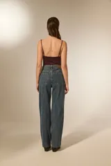 Pantalón jean azul de corte recto y calce alto, con bolsillos y detalles de strass.