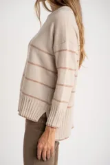 Sweater de punto oversize en color beige melange con diseño de líneas horizontales tostadas, cuello redondo y terminaciones en rib.