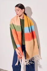 Bufanda larga tejida a rayas horizontales en tonos naranja, celeste, amarillo y beige, con flecos en los extremos.