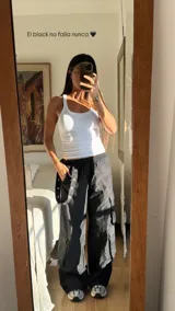 Pantalón estilo cargo parachute color blanco, de corte holgado, con cintura elástica y bolsillos laterales amplios con detalles de tiras y botones a presión.