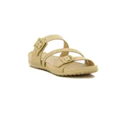 Sandalias bajas color crema con tiras cruzadas y hebillas ajustables.