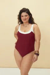 Malla enteriza de diseño bicolor, con cuerpo en color bordó y escote redondeado con borde en color blanco. Presenta breteles anchos y corte de pierna clásico.