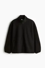 Buzo deportivo de polar cálido negro, con cuello elevado y medio cierre. Modelo de manga larga con hombros caídos y bolsillos laterales, de corte relajado.