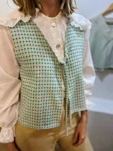 Chaleco con estampado geométrico en tonos turquesa y beige, con escote en V y lazo para ajustar en la parte delantera. Confeccionado en lino italiano reversible.