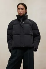 Campera acolchada negra, estilo puffer, con cuello alto y cierre frontal. Diseño oversize.