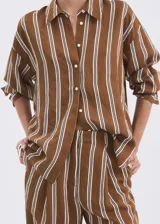 Camisa de diseño recto y manga larga con puños abotonados, confeccionada con estampado de rayas en tonos marrón y blanco. Cuenta con cuello camisero y cierre frontal de botones.