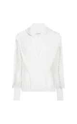 Sweater calado de punto color blanco, de corte recto con amplio cuello tipo polo y escote en V. Presenta mangas largas con volumen, puños ajustados y detalles de volados texturizados en la parte delantera y en las mangas.