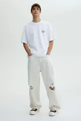 Remera blanca de punto de algodón, con cuello redondo y hombros caídos, corte holgado. Presenta un pequeño estampado en el pecho con el texto "MENTON FRANCE" en color oscuro.