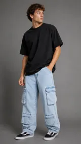 Pantalón cargo de denim en color celeste claro, con múltiples bolsillos utilitarios en los laterales de las piernas y corte holgado de estilo urbano.