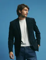 Saco sport de pana color marrón, con cuello de solapa, cierre frontal de dos botones, bolsillos laterales con tapa y puños con botones.