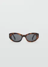 Gafas de sol con montura ovalada de pasta con estampado carey y lentes oscuras.
