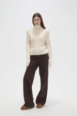 Saco de punto de algodón con diseño de trenzas, cuello alto y cierre frontal completo. Presenta un corte al cuerpo y mangas largas.
