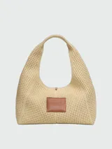 Cartera Marc Jacobs modelo The Lurex Crochet Sack Bag, color beige y dorado, tipo tote bag tejida en crochet de lurex con el texto 'THE SACK BAG MARC JACOBS' bordado en el frente.