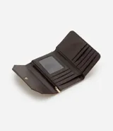 Billetera tipo sobre de tamaño mediano, confeccionada en material sintético efecto gamuza color tostado. Presenta un diseño acolchado con costuras diagonales y placa metálica dorada con el logo de la marca en la solapa frontal.