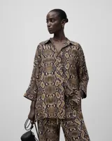 Camisa amplia con estampado de serpiente en viscosa responsable, cuello solapa, manga japonesa bajo codo y botonadura frontal.