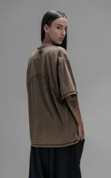 Remera de manga corta con calce oversize, confeccionada en algodón con proceso batik artesanal. Presenta recortes superpuestos y costuras expuestas en el frente, espalda y mangas.