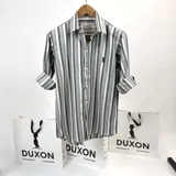 Camisa de manga larga a rayas verticales en tonos grises, con cuello italiano y logo bordado en el pecho.