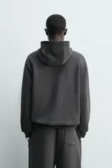 Sudadera tipo hoodie de corte relajado, confeccionada en tejido fluido con efecto lavado. Presenta cuello con capucha, mangas largas y terminaciones en rib.