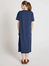 Vestido largo azul marino de corte recto y silueta relajada, con escote redondo, mangas cortas y cierre frontal parcial de botones. Cuenta con aberturas laterales en el bajo.